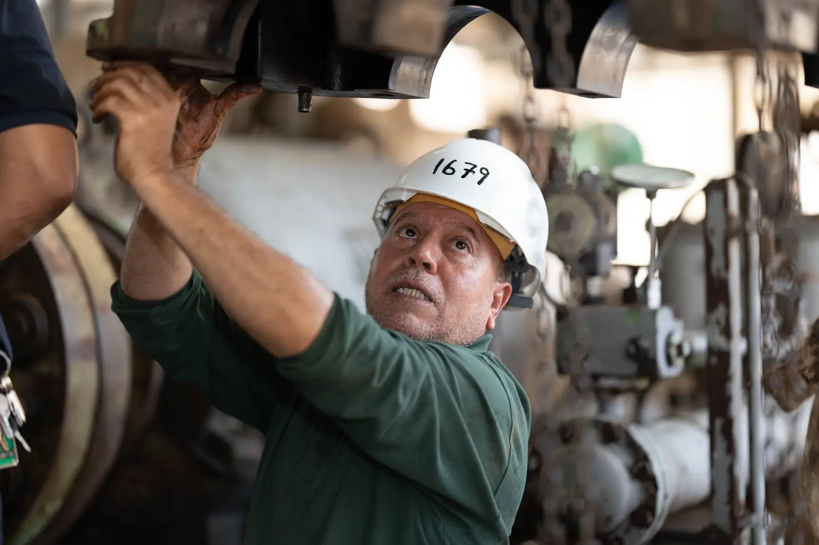 A maintenance technician inspecting equipment overhead